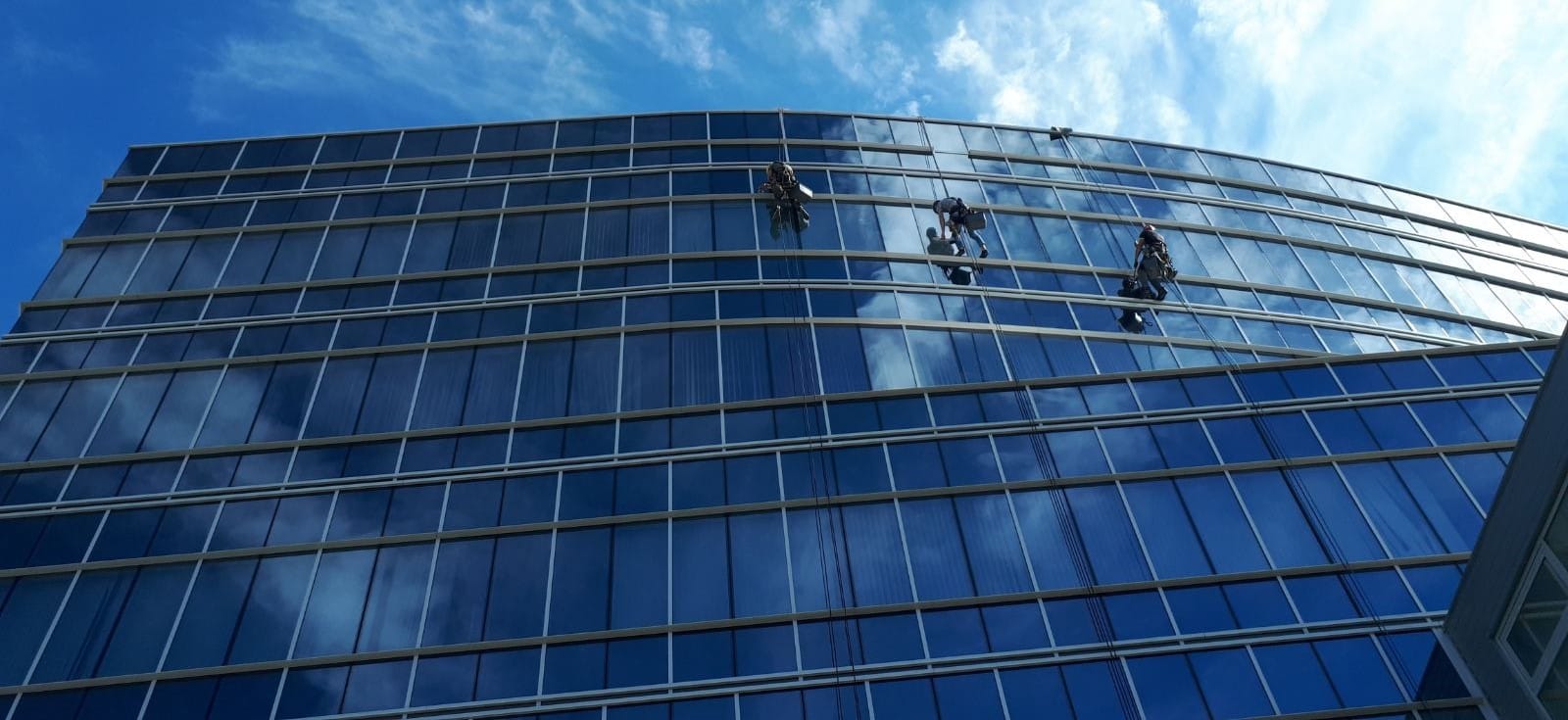 Alpiniști utilitari spălând ferestrele unei clădiri de birouri din Chișinău